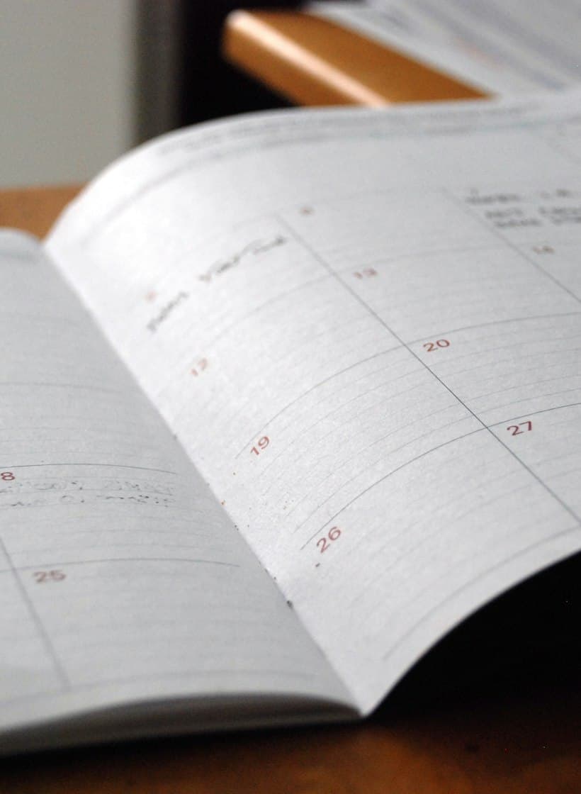 An open monthly planner on a wooden desk