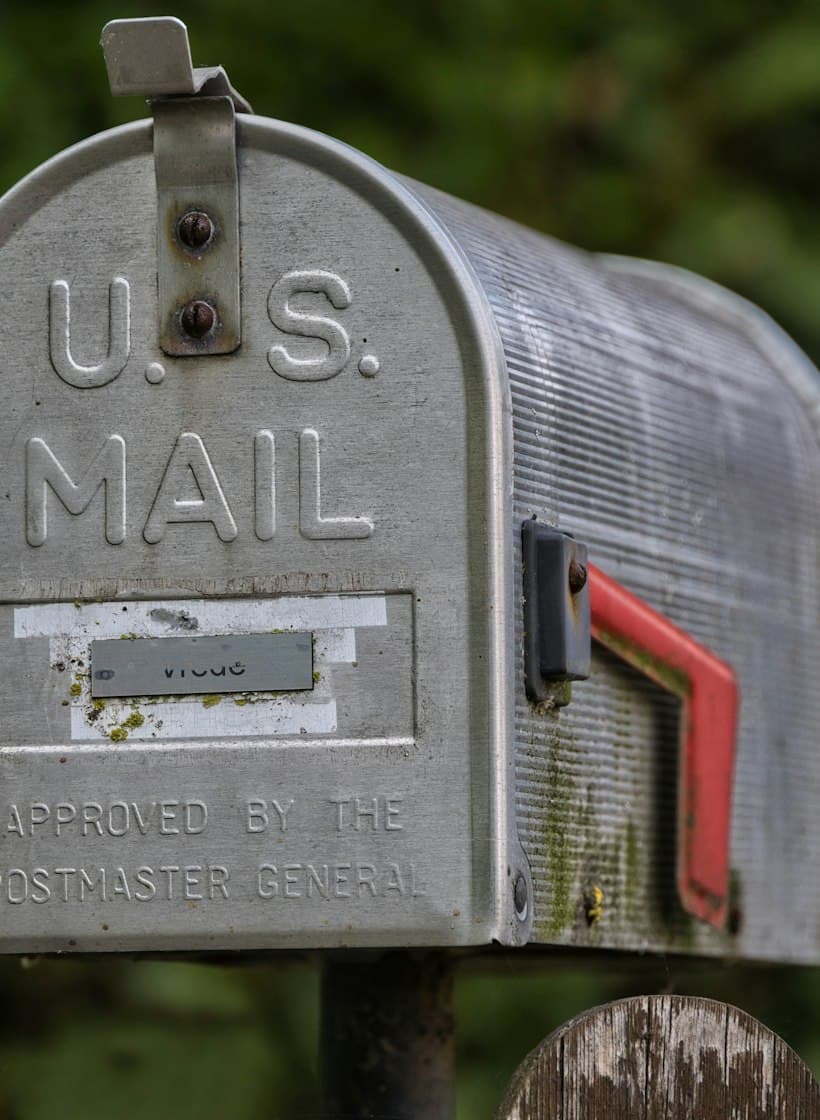 A weathered U.S. mailbox with its red flag raised